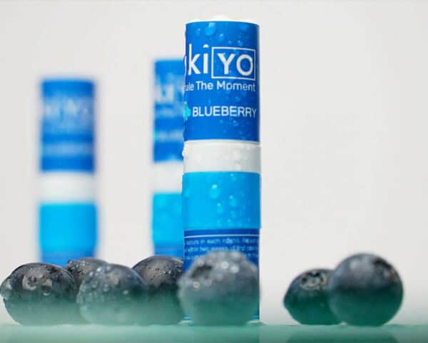 Blueberry Single Pack-flavored vaping pods arranged in a line with blueberries in the foreground, focus on the central pod.